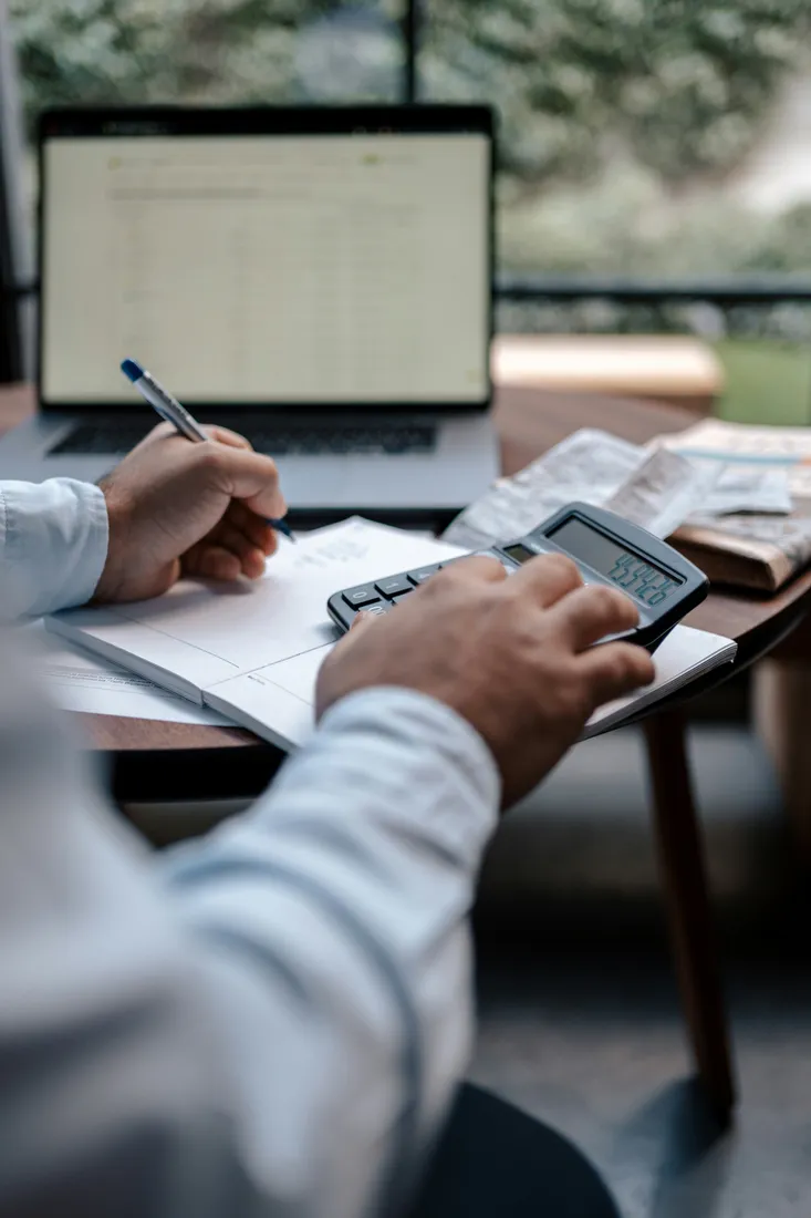 Bookkeeper working with a calculator and laptop